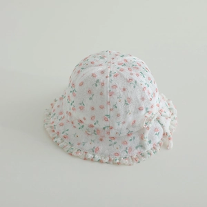 Close-up of baby sun hat with pink floral lace pattern and delicate bow details