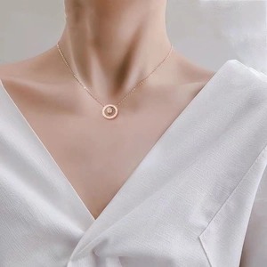 Elegant rose gold triple-layer circular pendant necklace worn by a model with V-neck top