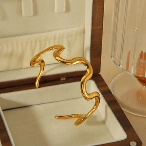 Elegant 18k gold plated stainless steel wavy bangle on a premium velvet jewelry box
