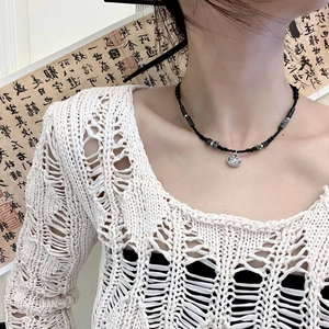 Collier de perles style bambou avec pendentif cadenas argenté sur un mannequin femme