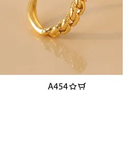 Macro shot of gold chain-link ring with micro-pave cubic zirconia on ivory textured base
