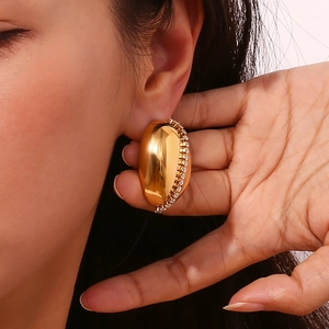 Polished 18K gold plated bean-shaped stud earrings with pavé zircon stones on women's ear