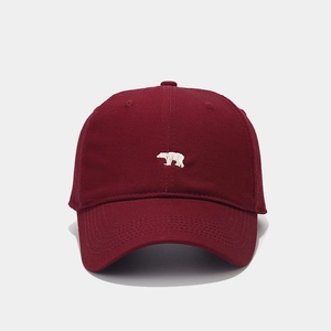 Detail shot of white polar bear embroidery on a burgundy cotton twill baseball cap