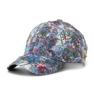 Dettaglio del cappello floreale vintage con tessuto strappato effetto usurato e visiera sfrangiata