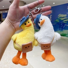 Close-up of cute plush duck keychains in white and yellow with blue hats and brown bags