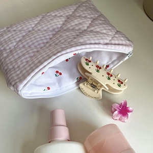 Detail of purple plaid quilted makeup bag featuring cute cherry print inner lining