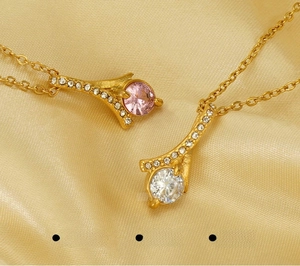 Macro shot of stainless steel pendant with sparkling rhinestones on golden silk background