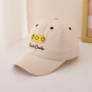 Detail der beigen Baumwoll-Baseballkappe mit Triple Smile-Stickerei und gelben Smileys
