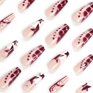 Faux ongles ballerine rose nude avec des motifs de silhouettes d'étoiles et strass