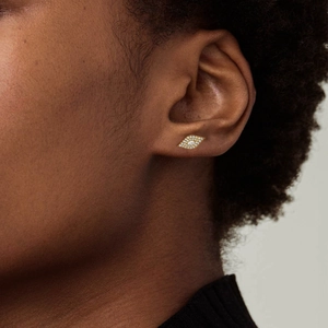 Close-up of gold marquise-shaped earrings with micro-pave cubic zirconia on ear
