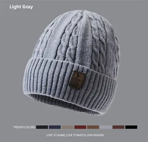 Macro detail of thick cable knit texture and leather patch on grey winter beanie hat