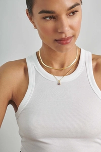 Detail of gold snake chain and triangle purple zircon pendant necklace on a model