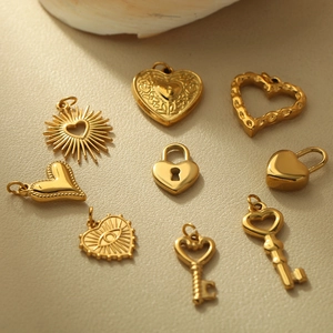 Assorted gold stainless steel heart and key pendants arranged on beige leather texture