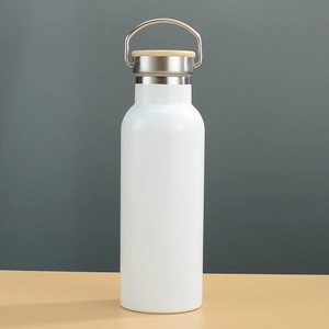 Detail of white stainless steel thermos with bamboo lid and silver metal handle