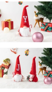 Detail of red knitted Christmas gnomes with J and Y letters on a snowy background