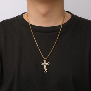 Close-up of golden stainless steel cross pendant with cubic zirconia and box chain