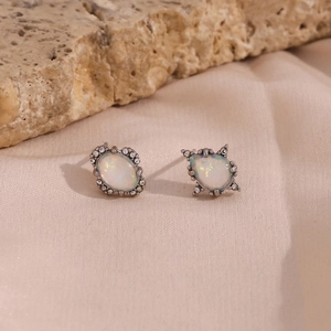 Details von Vintage-Opal-Ohrringen mit Zirkonia auf rosa Satin und Naturstein
