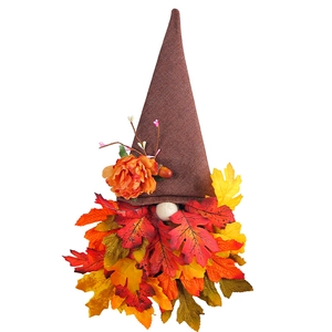 Fall gnome decoration with brown textured hat, orange flower, and colorful autumn leaf beard