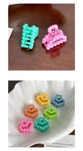 Macro detail of matte candy-colored mini hair claws with heart-shaped handle design