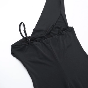 Détail d'une robe noire en maille montrant la fine bretelle ajustable et la couture