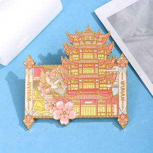 Detail view of pink and gold enamel Huanghelou tower magnet with cherry blossoms and cranes
