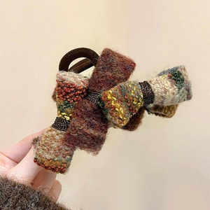 Détail d'une pince à cheveux vintage en tweed avec un tissu tissé multicolore élégant