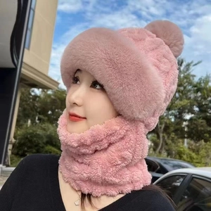 Detailed view of a pink plush winter hat with integrated neck warmer on a model