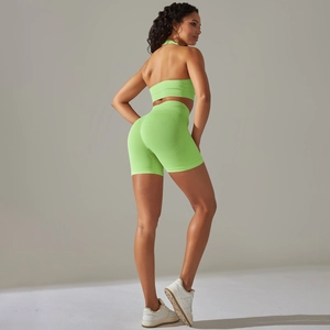 Dettaglio del set da yoga a coste verde neon con pantaloncini a vita alta e reggiseno sportivo