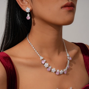 Detailed view of luxury flower zircon necklace and earrings set on red velvet attire
