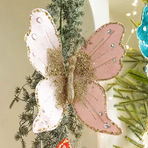 Pink decorative Christmas butterfly with gold sequins and beads on a festive tree branch