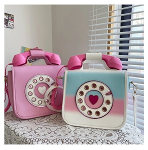 Detail view of creative retro telephone-shaped handbags in pink and gradient colors