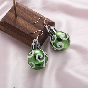 Detail of green Christmas ball earrings with white glitter spirals on pink satin fabric