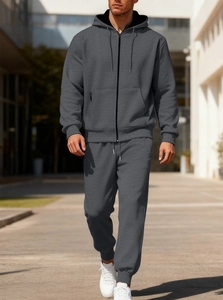 Outdoor shot of men's grey tracksuit featuring zipper hoodie and drawstring jogger pants