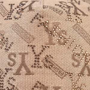Macro detail of brown baseball cap featuring textured STYLE letters with glitter rhinestones