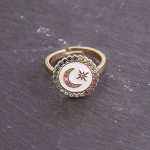 Macro detail of gold star and moon emblem ring with colorful cubic zirconia accents