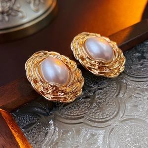 Elegant vintage oval pearl stud earrings with woven gold-tone metal base in retro style
