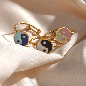 Detailed view of three 18K gold plated rings with colorful Tai Chi enamel and twisted band
