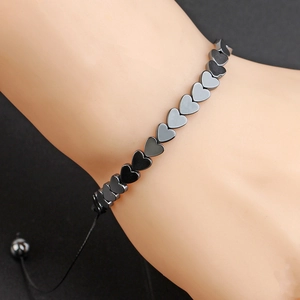 Detail of adjustable woven bracelet with black heart-shaped hematite beads on wrist