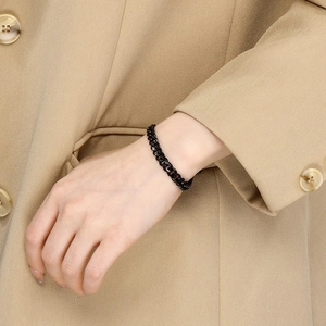 Classic black stainless steel link chain bracelet worn with a beige suit jacket