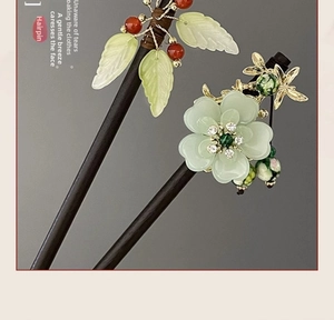 Macro detail of Chinese style hairpins with glass petals, red beads and golden butterfly