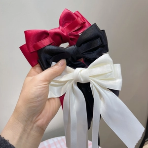 Elegant satin bow hair clip with long ribbons in wine red, black, and creamy white