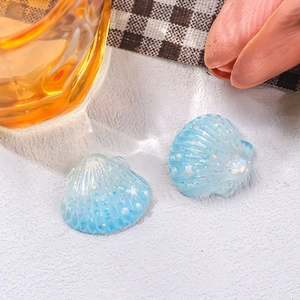 Macro detail of small blue glitter resin shells with white stars for DIY hair clips