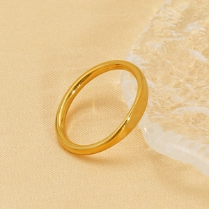 Minimalist 18K gold-plated stainless steel band ring shown in a luxury lifestyle setting