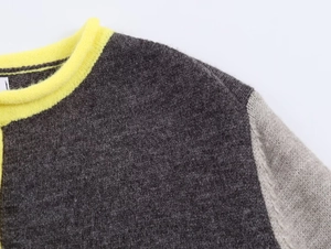 Detail of color-block knit sweater showing yellow ribbed neckline and gray fabric texture
