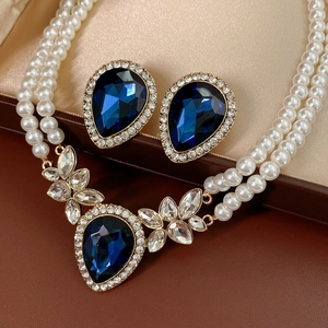 Détail d'une parure vintage avec pierres bleues en goutte d'eau et colliers de perles