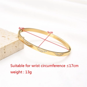 Detail shot of golden wavy stainless steel bangle showing 6cm and 5cm inner diameters
