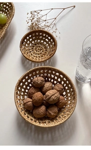 Handcrafted round rattan woven trays for serving nuts and fruits in a rustic home setting