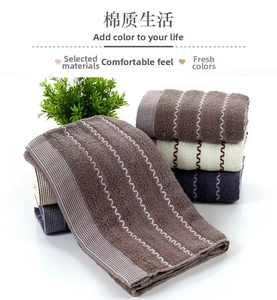 Close-up of premium cotton towels showing wavy woven textures and striped borders in various colors