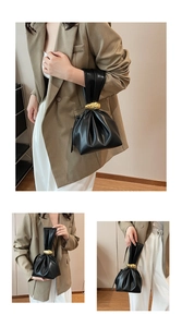 Close-up of black pleated leather bucket bag with artistic gold irregular metal buckles