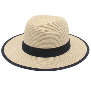 Panama straw sun hat with black ribbon edge and metallic M detail on white background